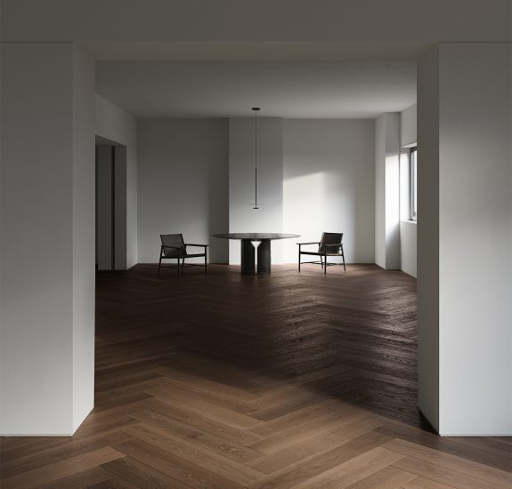 Fußboden in Parkettoptik, gefliest mit Living Ceramics Holzoptik-Fliesen Due, die an Walnuss-Parkett erinnern, in einem hellen Wohnzimmer