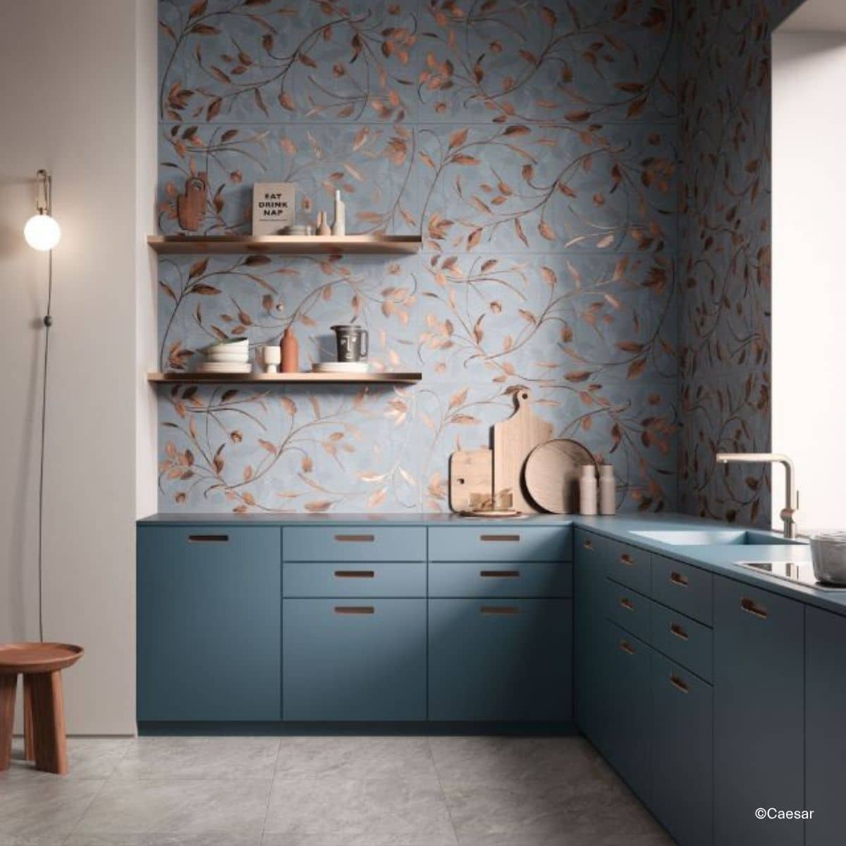 Küchenrückwand gefliest mit den Deco Solutions Fliesen von Caesar, die eine Fläche mit Blätterranken in Metallic-Farben auf blauem Hintergrund ergeben