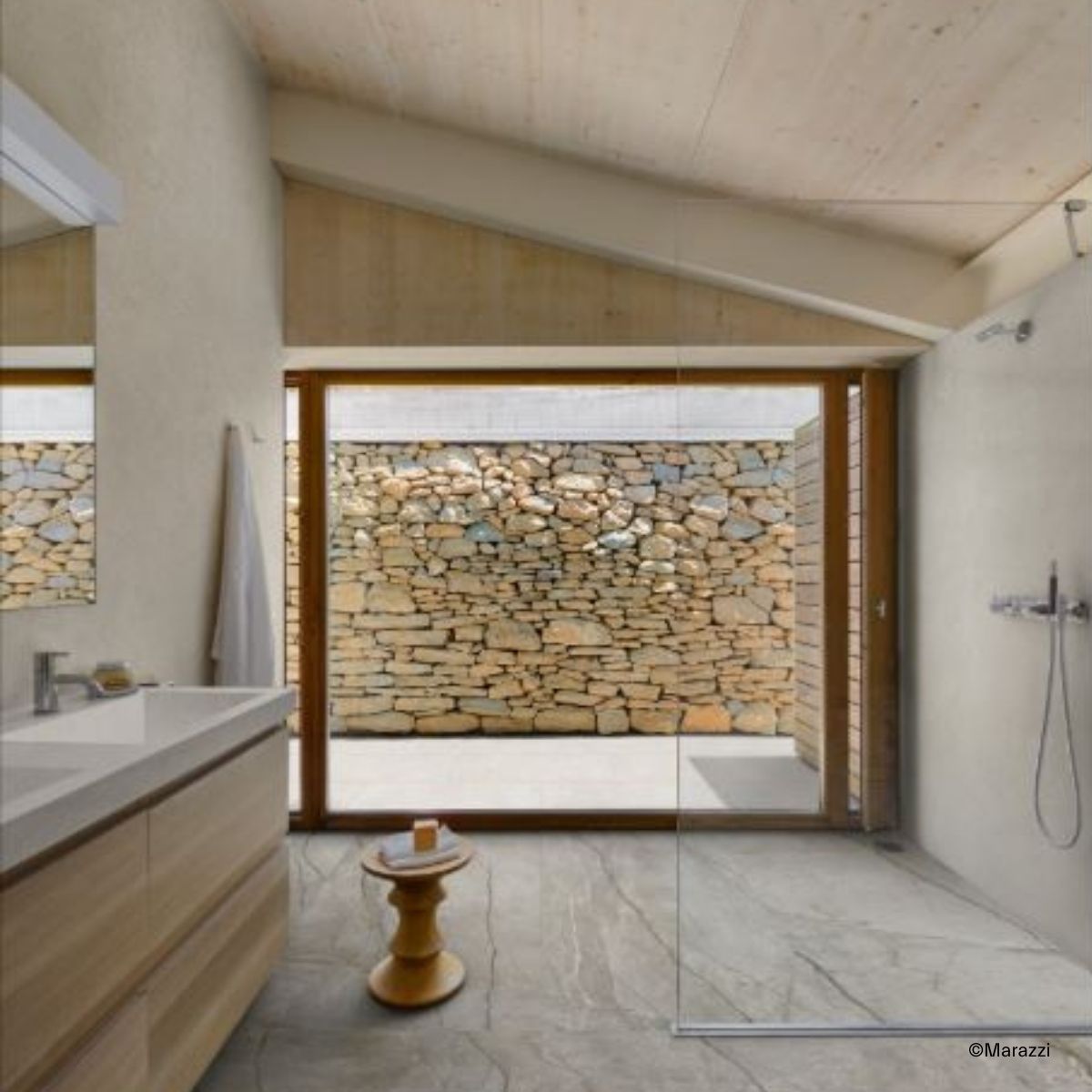 Helles Bad, gestaltet mit Marazzi Mystone Silver Root Natursteinoptik-Fliesen und mit einer offenen, geräumigen, bodengleichen Dusche, die nur zu einer Seite hin mit einer Glaswand abgetrennt ist