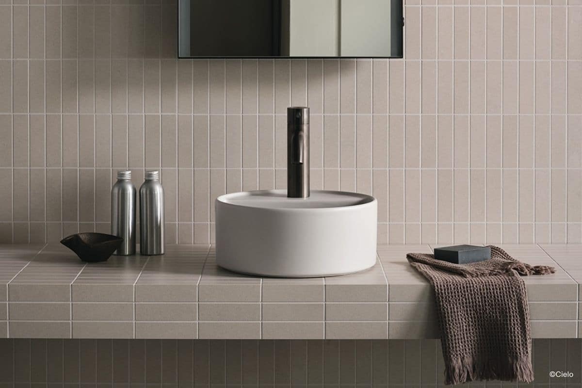 Gäste-WC mit gefliestem Waschtisch und Spritzschutz in Hellbeige plus einem runden Waschbecken namens Round Washbasin One Hole von Ciele