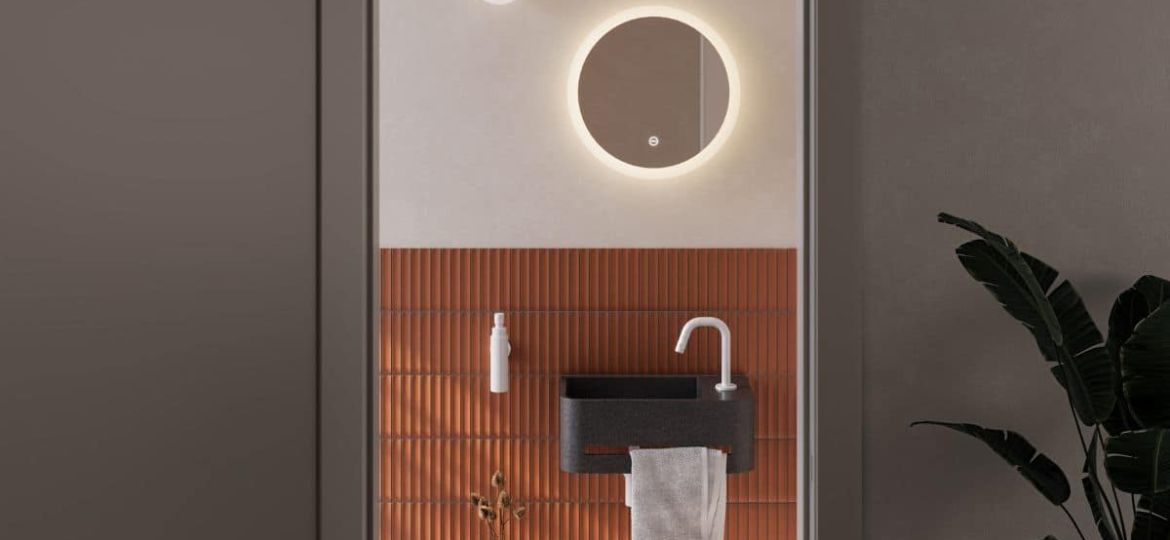 Blick in ein kleines Gäste-Wc mit halbhoch gefliester, oranger Wand, Mini-Waschtisch und Spiegel (Credit: Clou)