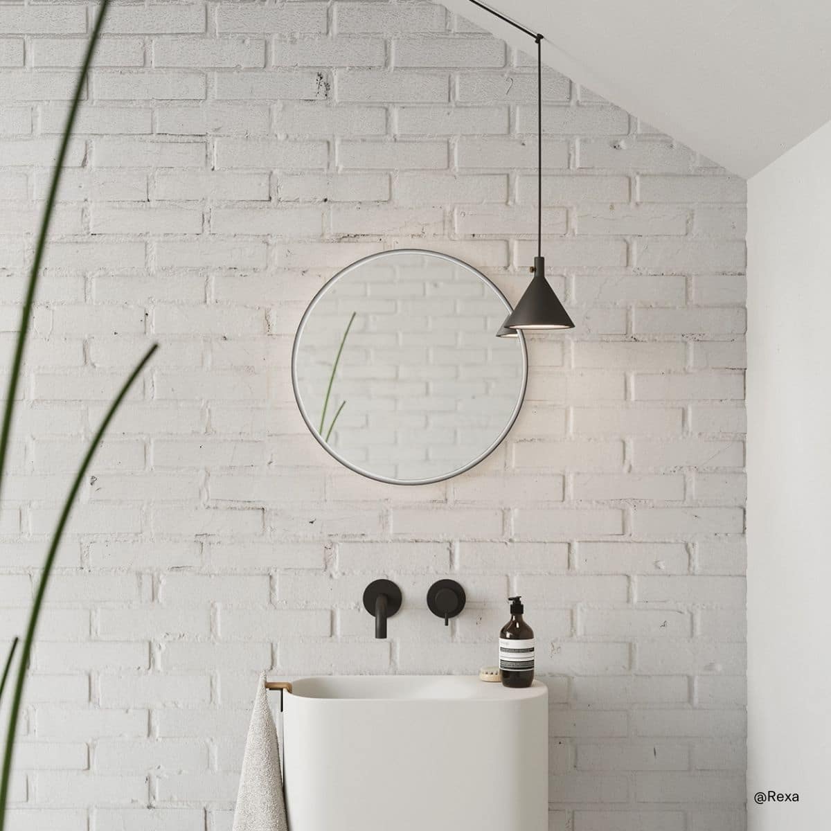 weißes Mini-Waschbecken Ptit von Rexa vor weißer Backsteinmauer in einem kleinen Badezimmer mit rundem Spiegel darüber und eine Schwebelampe darüber