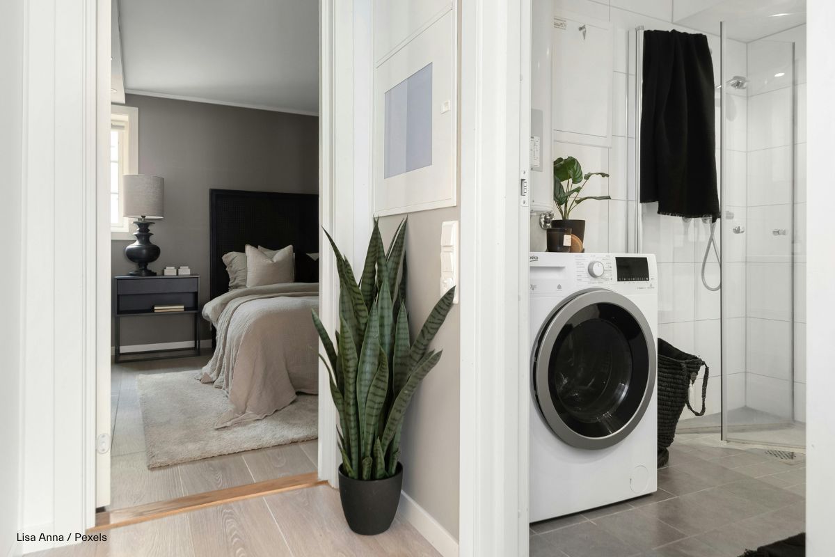 Blick aus einem Wohnungsflur in ein kleines Badezimmer mit Waschmaschine