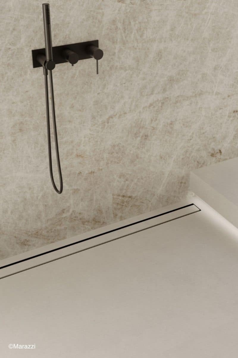 Dusche mit Marazzi Fliesen der Serie Grande Marble Look in Sand sowie einer schwarzen Armatur