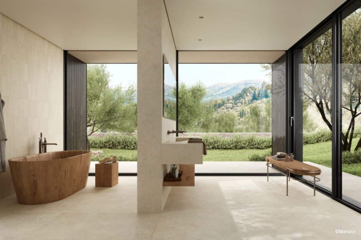 Helles beiges Bad mit freistehender Badewanne in Holzoptik und Fliesen aus der Serie Mystone Tivoli Bianco von Marazzi
