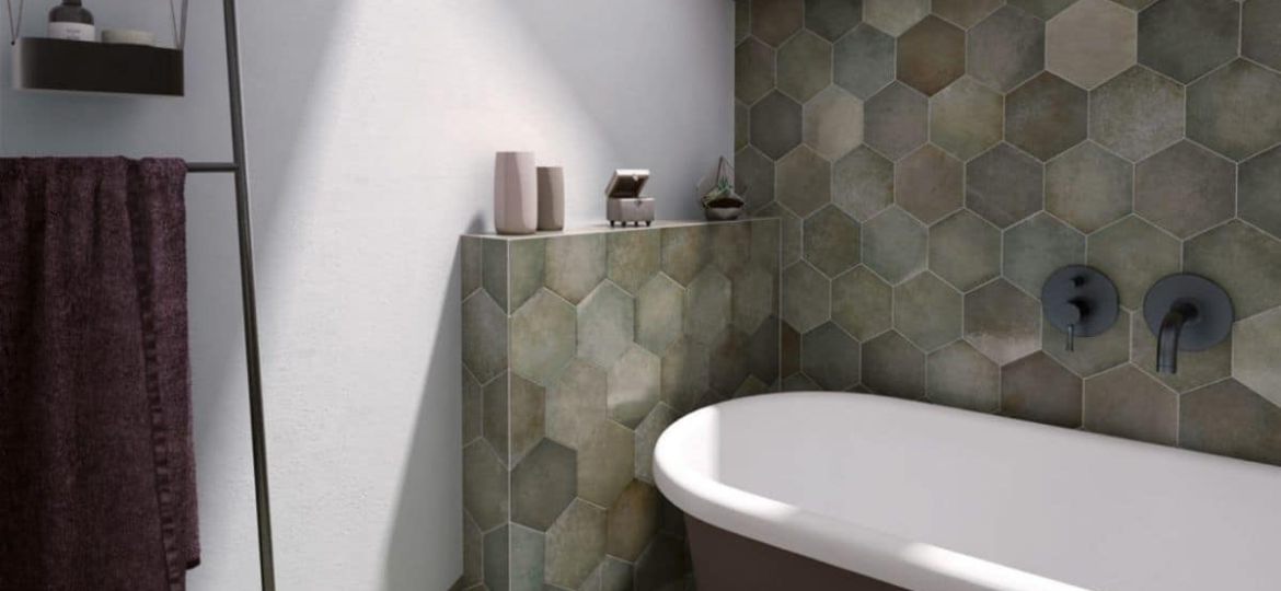 Badezimmer gefliest mit den grünen Hexagon-Fliesen der Serie Heritage Jungle von Equipe, wobei die lange Wand hinter der Badewanne bis zur Decke gefliest ist, die kurze Wand hinter der Wanne halbhoch und die daneben gar nicht gefliest ist