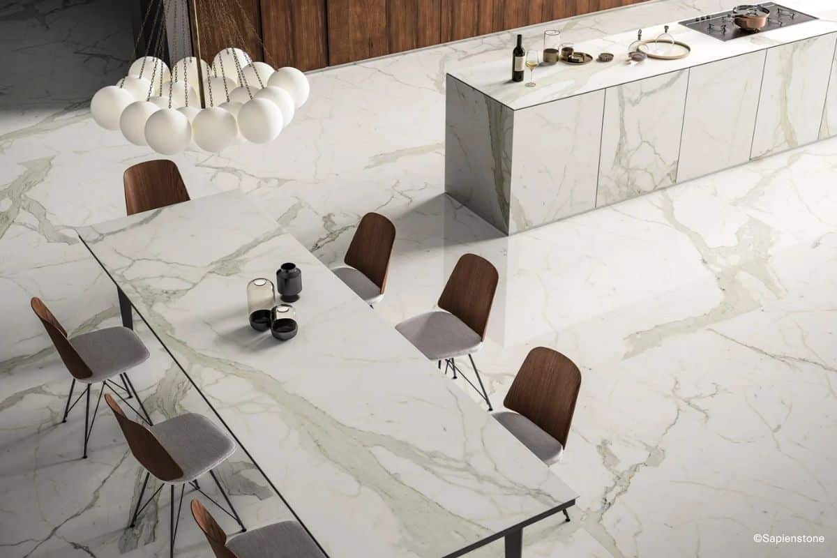 Essbereich und offene Wohnk&uuml;che sowie Esstischplatte gestaltet aus den Sapienstone Marmoroptik-Fliesen der Serie Calacatta in heller Optik